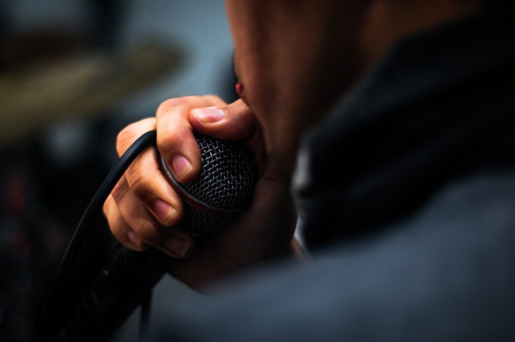hombre cantando junto a un micrófono en la preproducción en música urbana